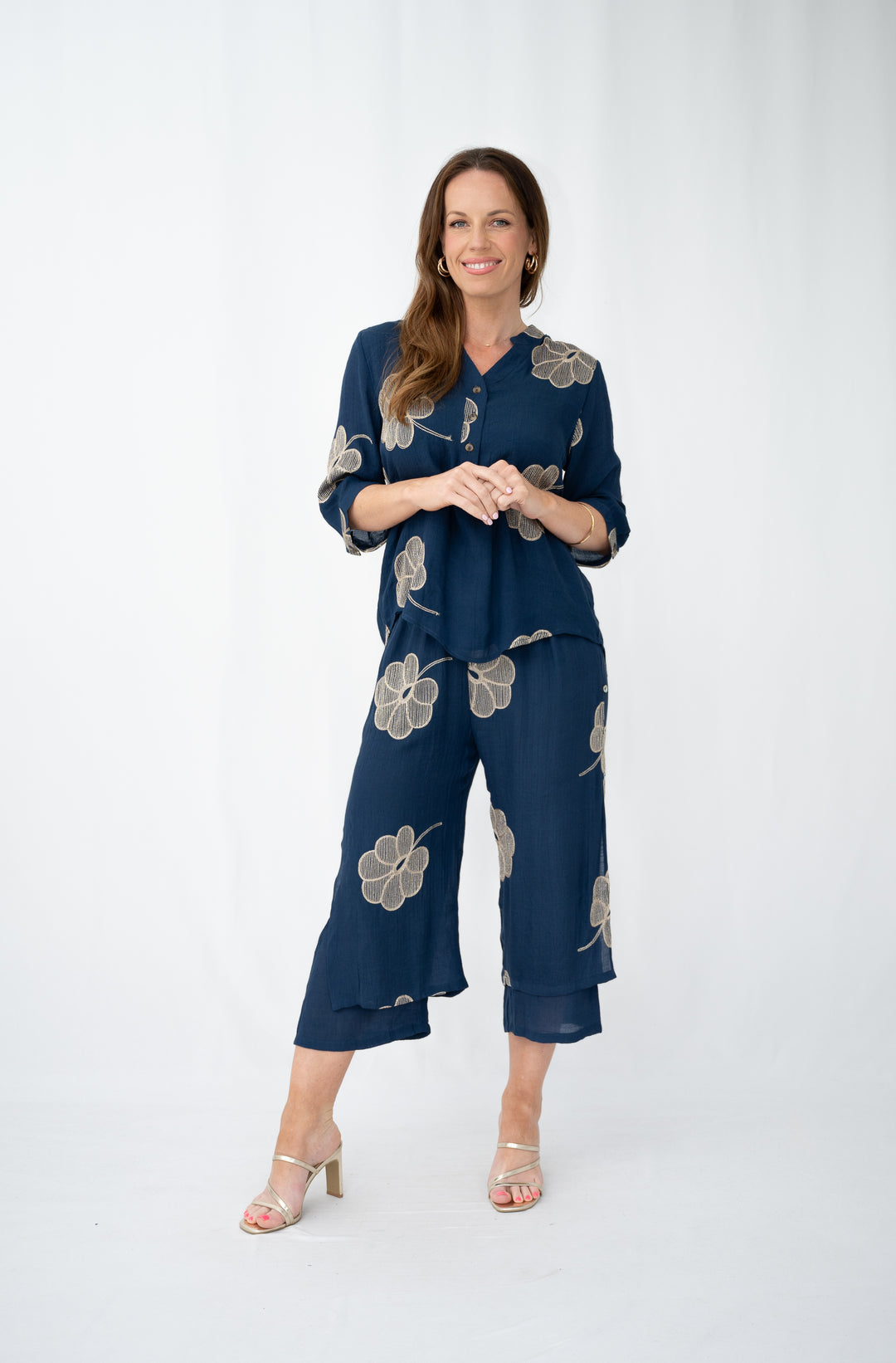 Woman wearing a navy blue floral outfit on a white background