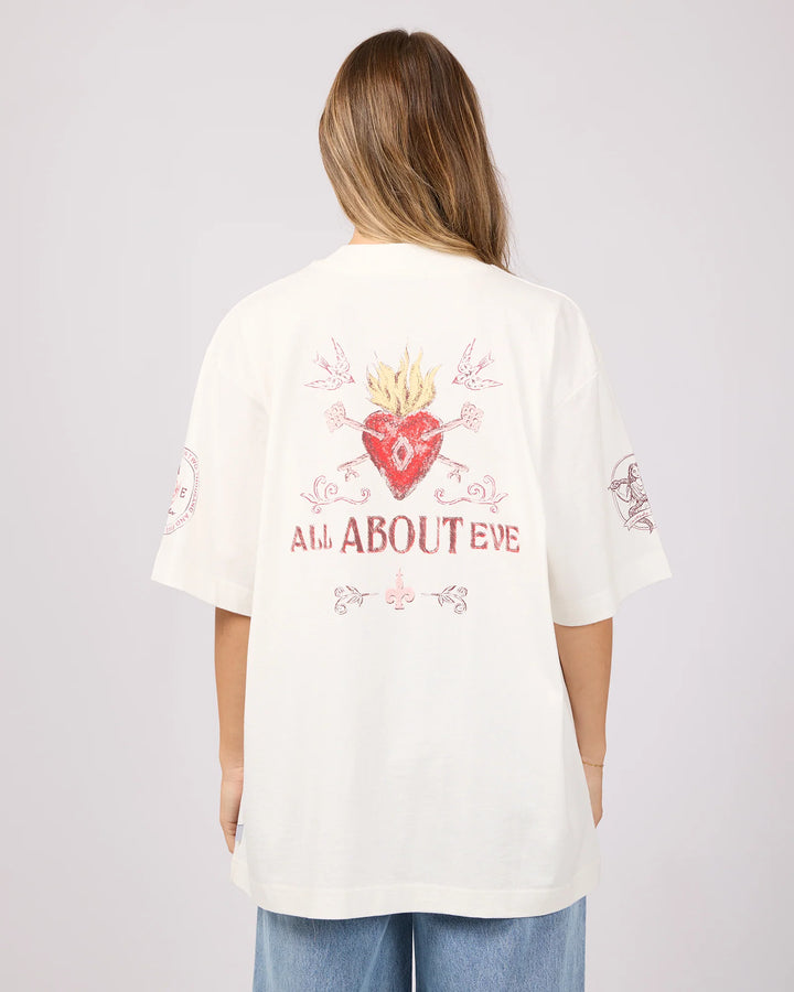 Person wearing a white t-shirt with a red heart design and text on the back, standing against a plain background.