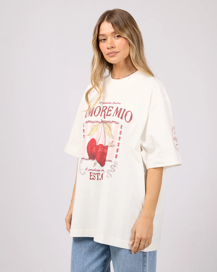 Woman wearing a white t-shirt with graphics and text on a plain background