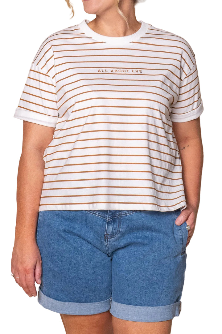 A woman wearing a white short-sleeve crewneck t-shirt with thin brown horizontal stripes and the text &