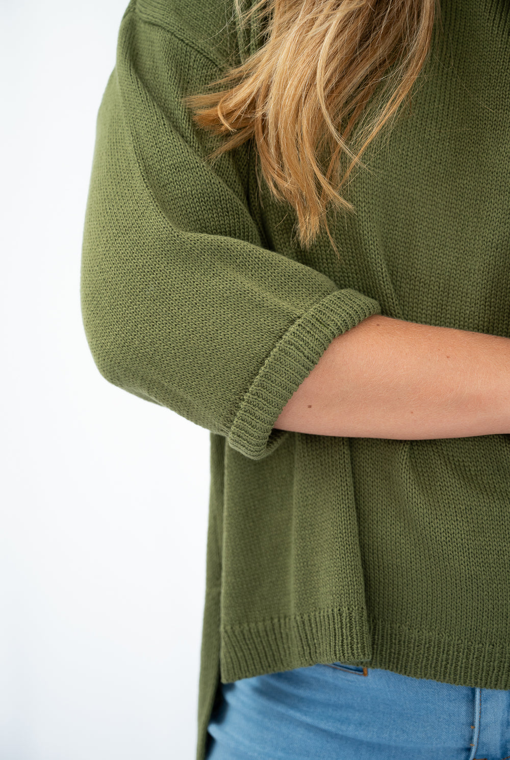 Green sweater worn by a person on a white background