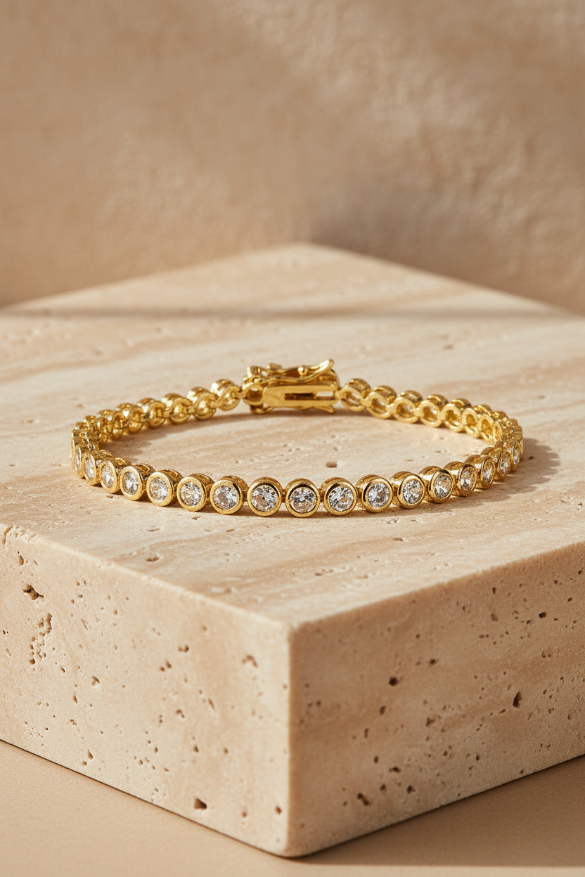 Gold bracelet with clear stones on a white background
