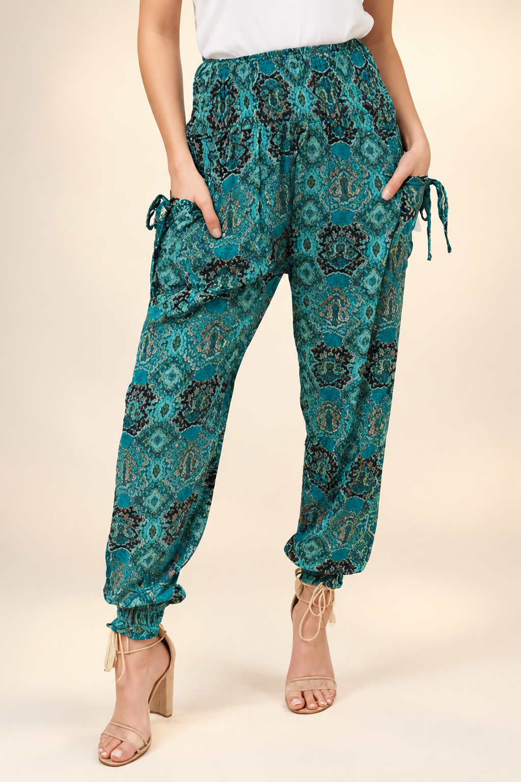 A pair of turquoise printed yoga pants with elasticated waistband and cuffs, worn by a model standing against a neutral background.