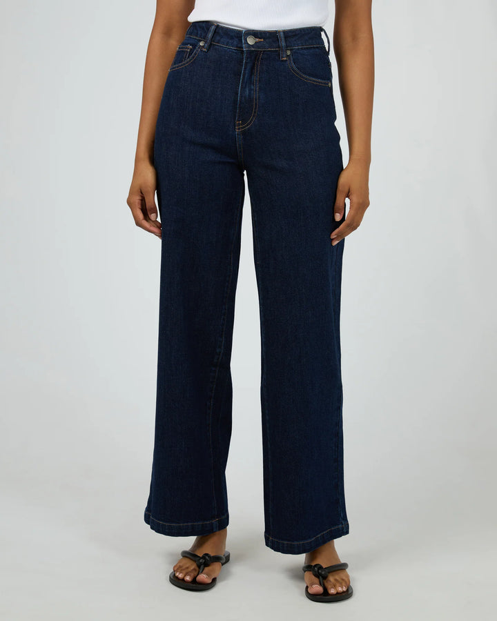 Person wearing dark blue jeans on a white background