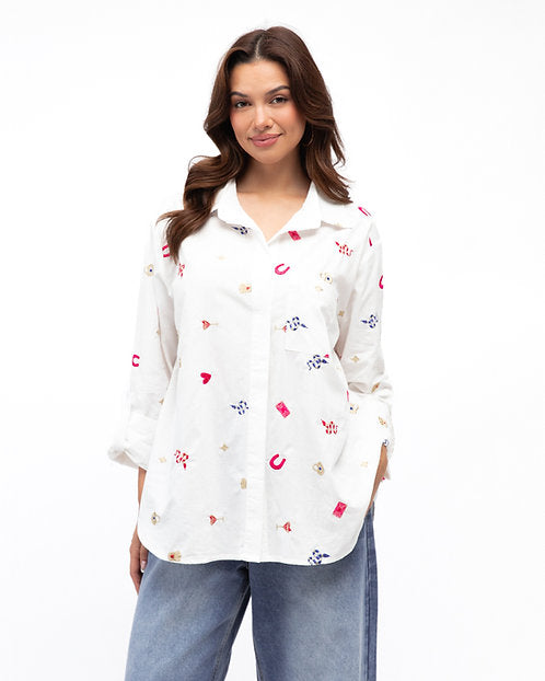 Woman wearing a white blouse with colorful patterns on a white background