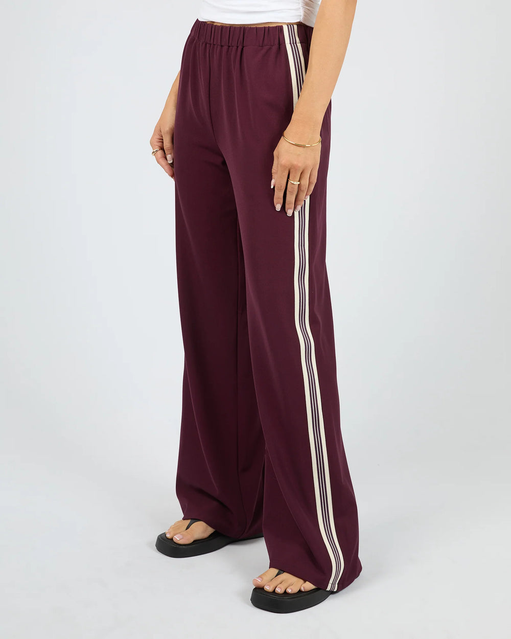 Maroon wide-leg pants with white stripes on a white background