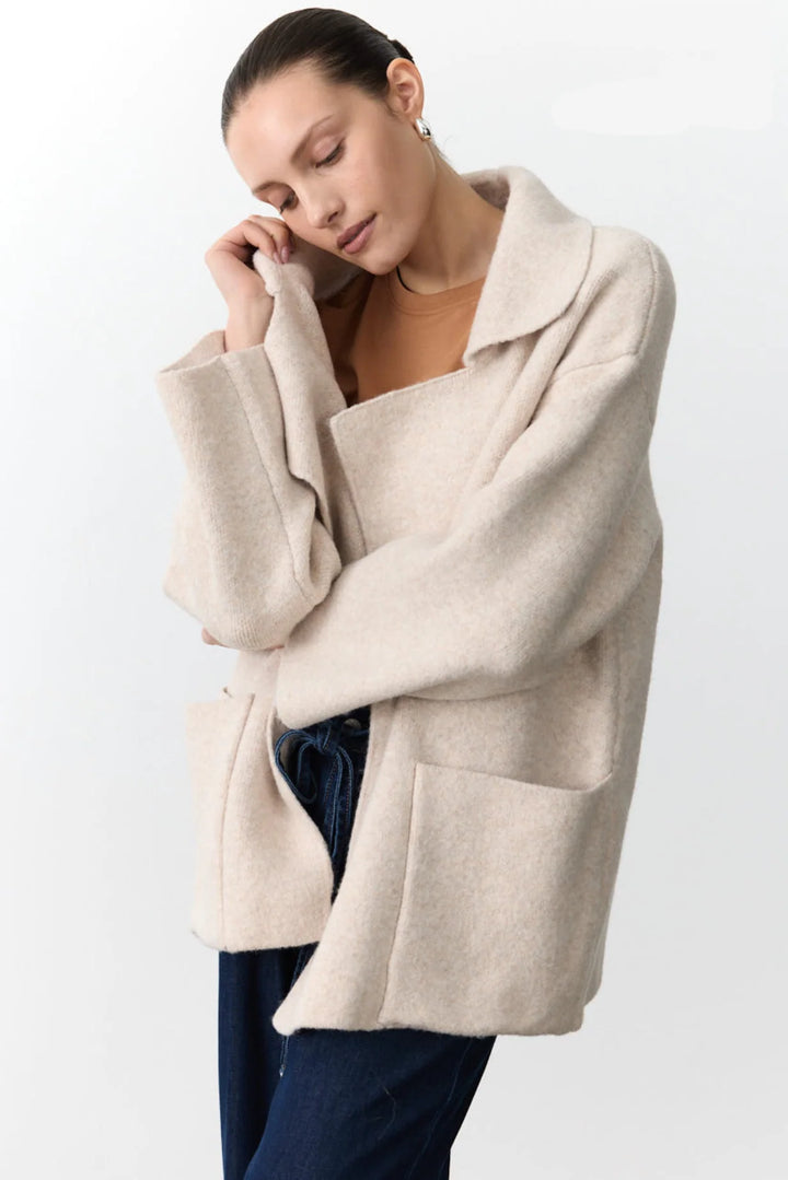 Woman wearing a beige coat against a white background