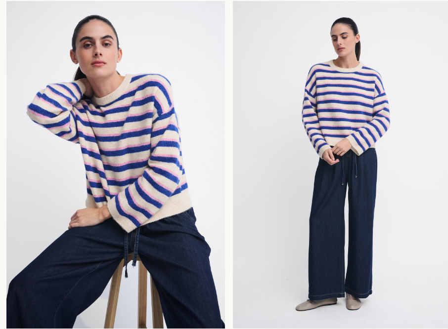 A model wearing a blue and cream striped knit sweater and dark wide-leg pants, shown in two studio poses against a light gray background.