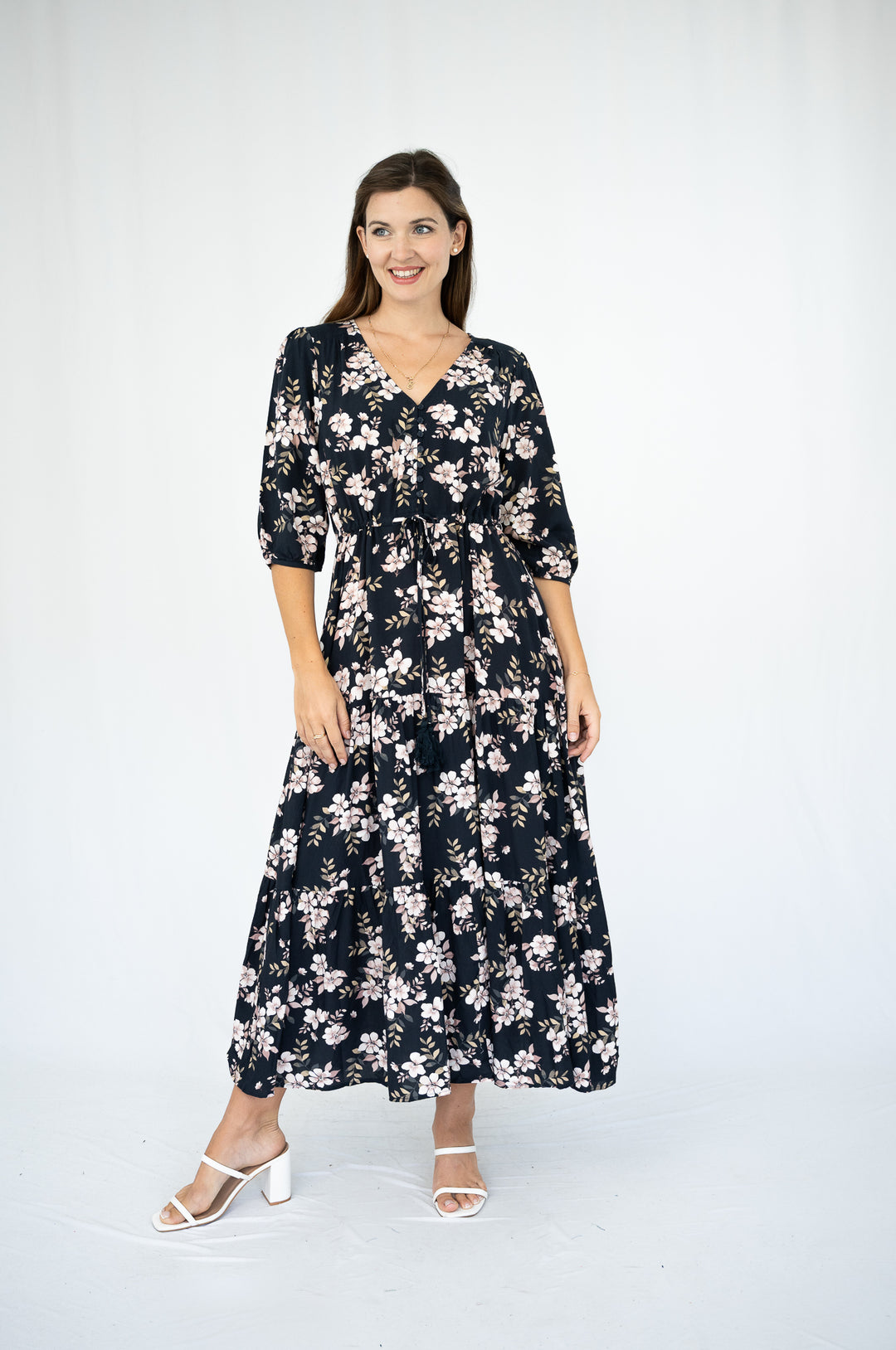 Woman wearing a black floral dress on a white background