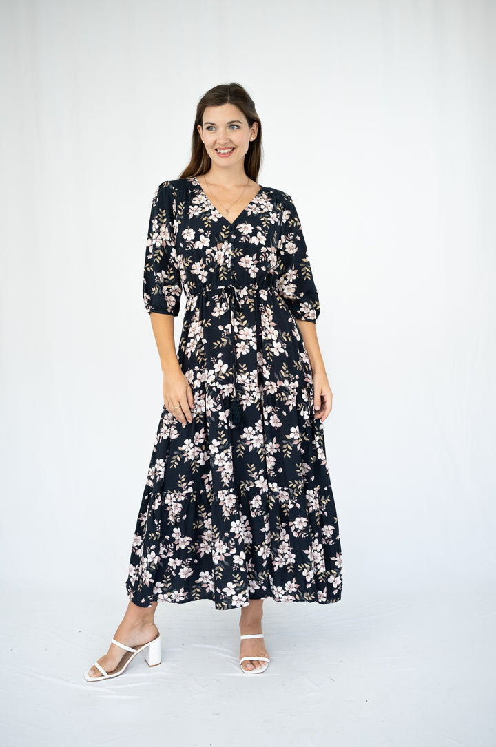 Woman wearing a black floral dress on a white background