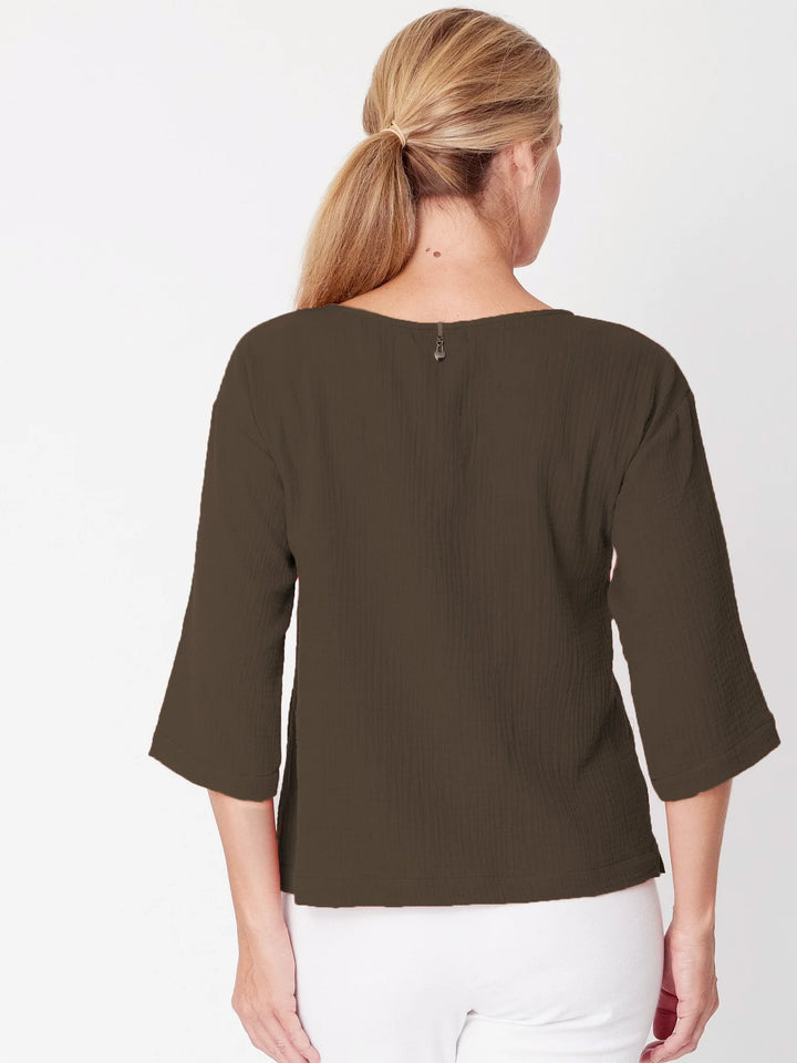 Woman wearing a brown blouse with a plain white background