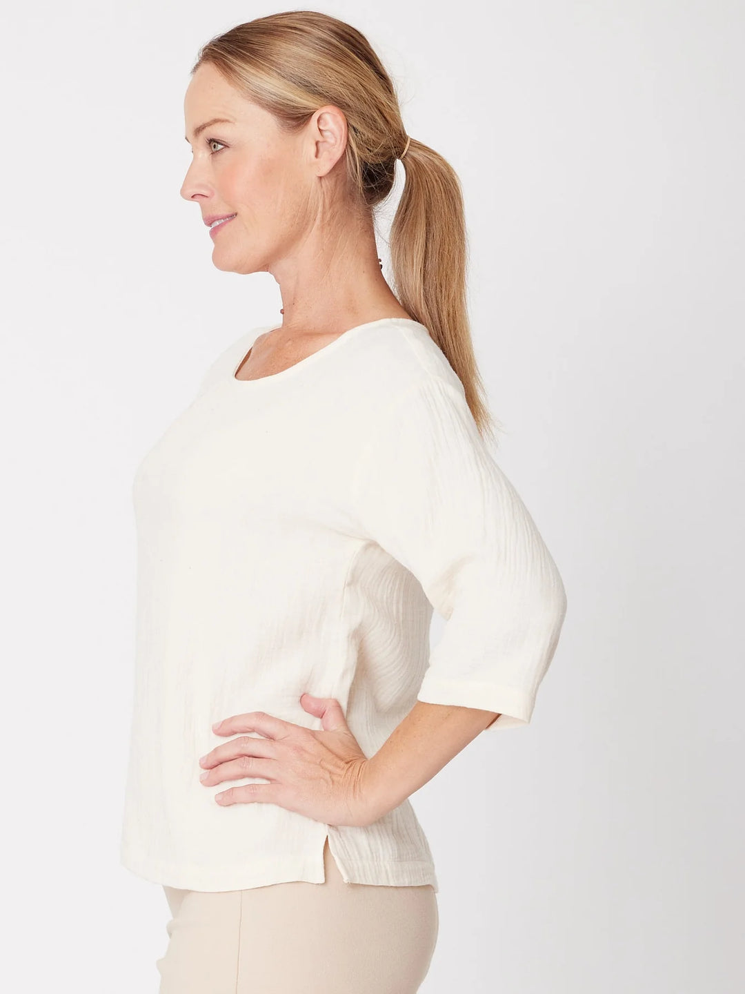 Woman wearing a white blouse against a plain background