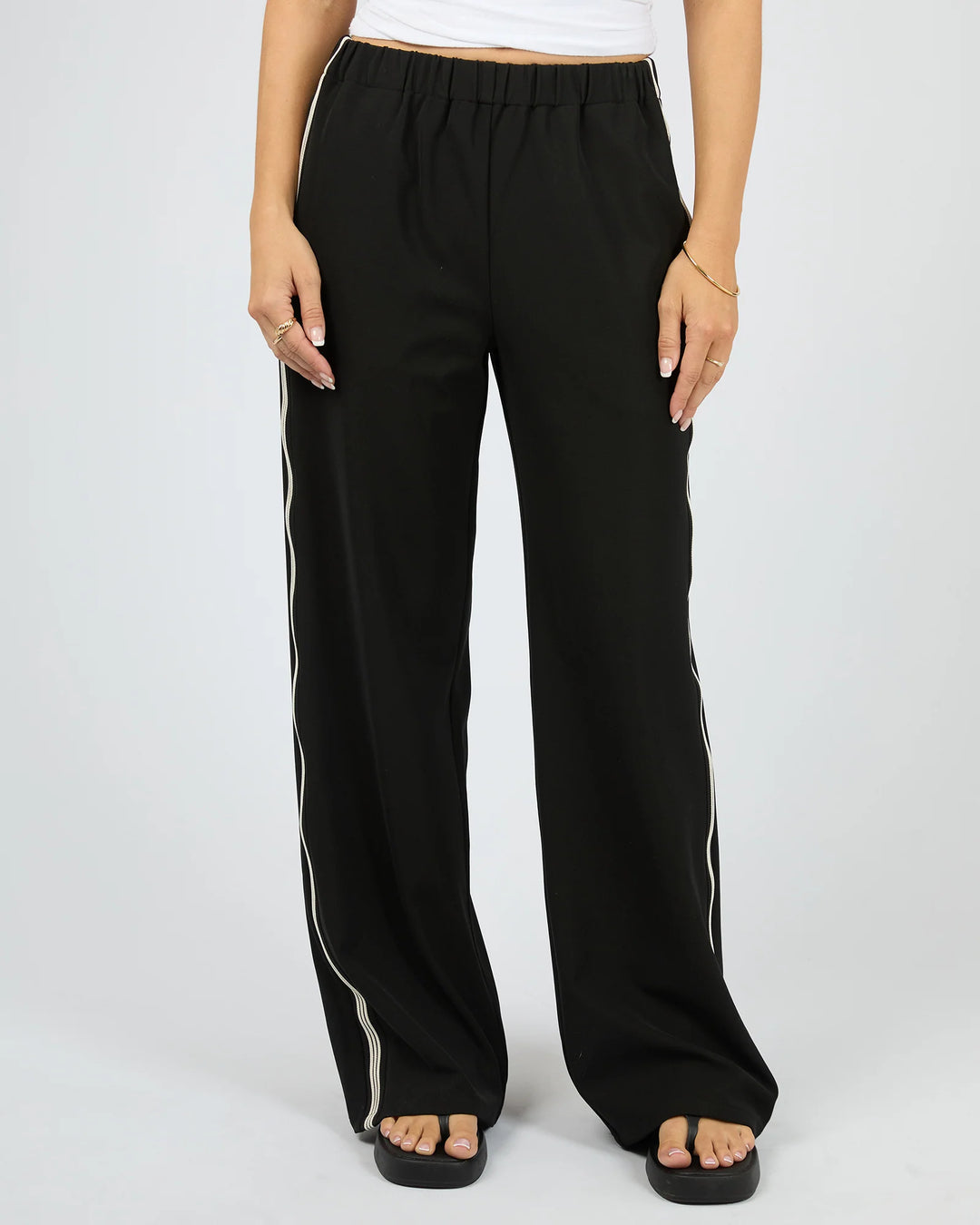 Black wide-leg pants with white stripes on a plain background