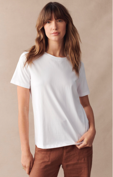 Woman wearing a plain white t-shirt against a beige background
