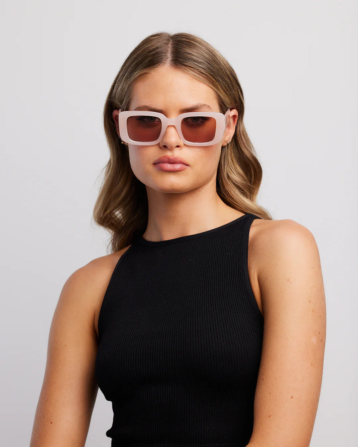 A woman wearing sunglasses with a black strapless top and black skirt.