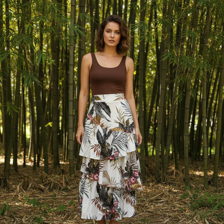 Woman in a brown top and floral skirt standing in a bamboo forest