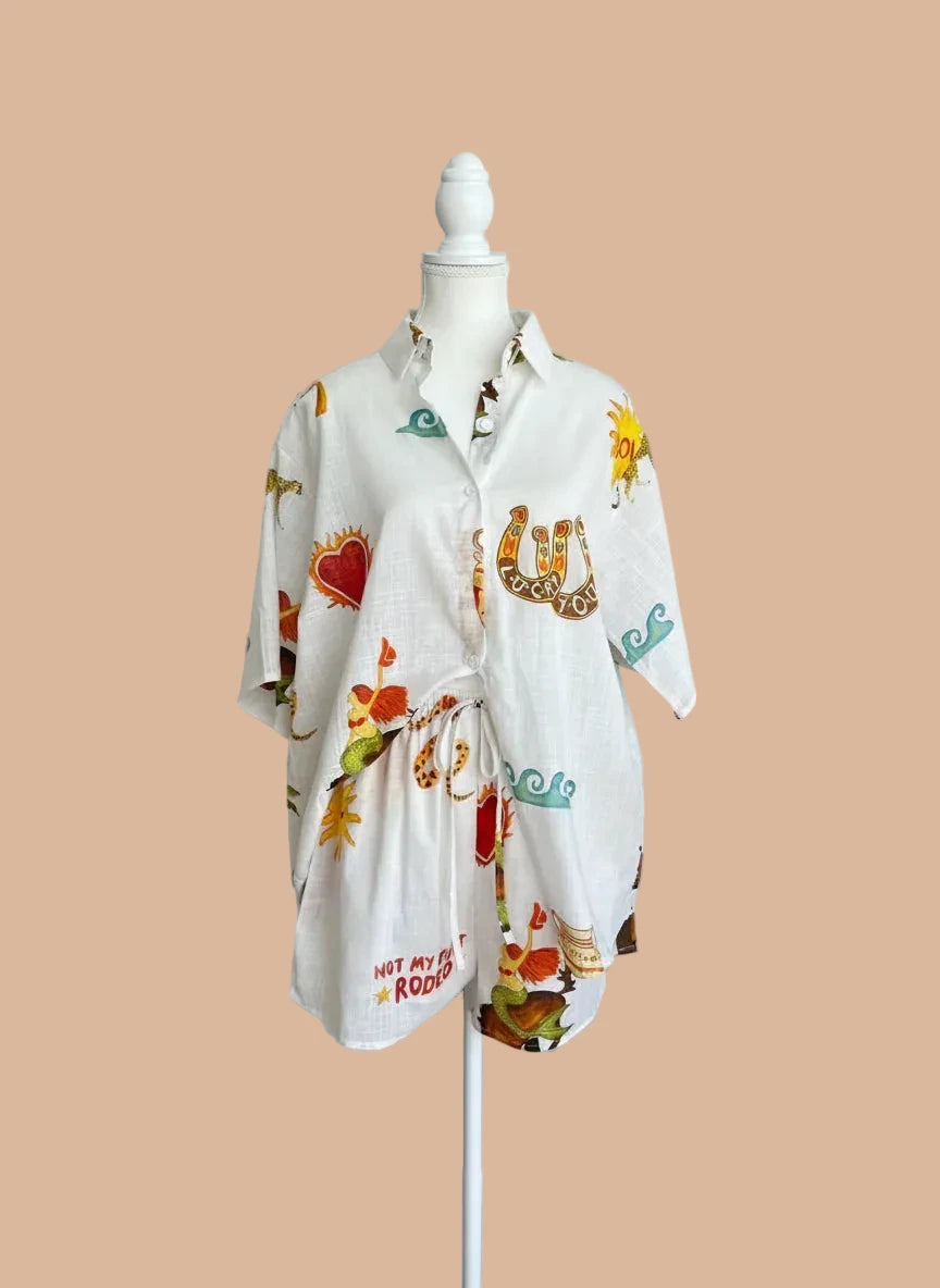 White shirt with colorful graphics on a mannequin against a gray background