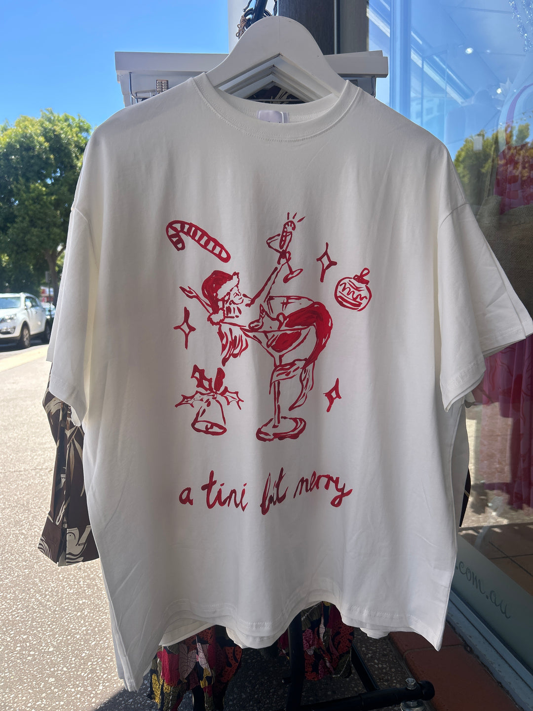  Festive white cotton tee featuring red sketch-style holiday artwork and playful slogan