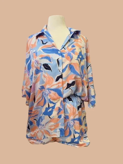 Colorful floral-patterned shirt on a mannequin in a store setting