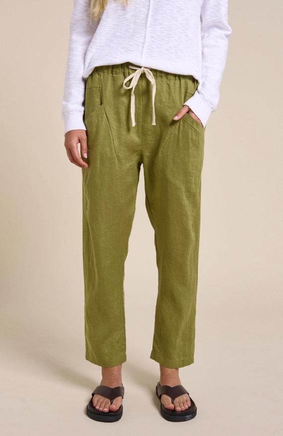 Person wearing green pants with a beige background