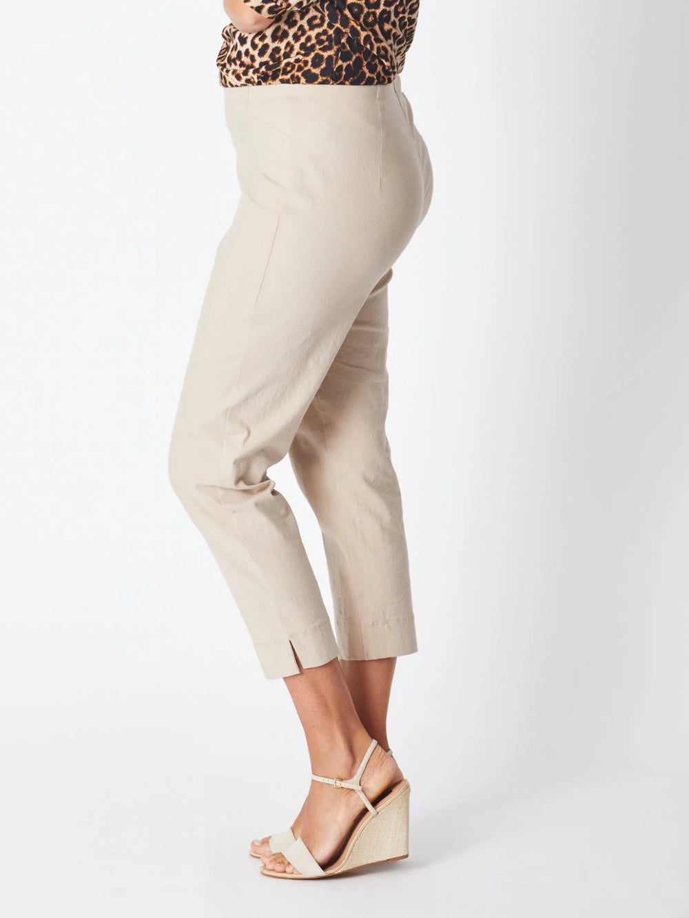 Beige pants worn by a person on a white background