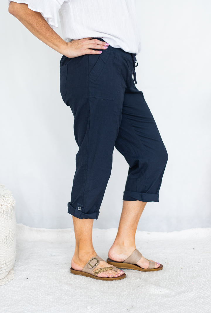 Person wearing navy pants and sandals on a white background