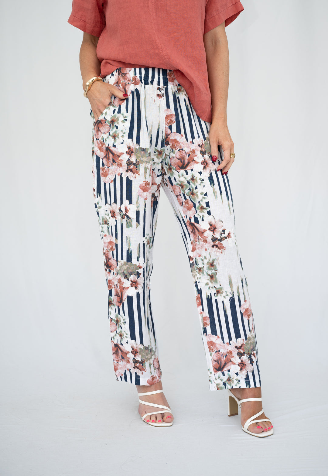 Person wearing floral and striped pants on a plain background