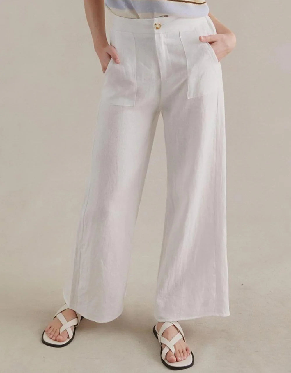 Person wearing white wide-leg pants on a plain background