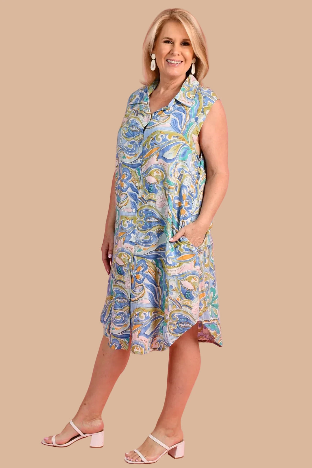 Woman wearing a patterned dress against a pink background