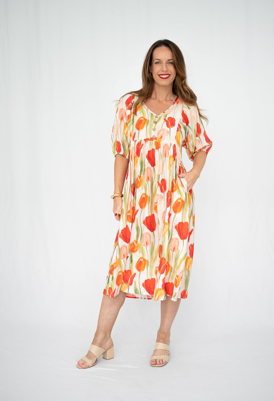 Woman wearing a colorful  willow tree floral dress on a white background